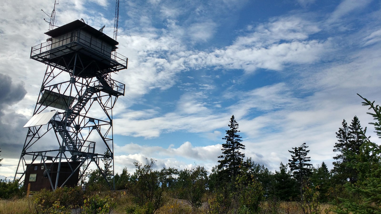 Ojibway Tower pierces a cloudy sky on a ridgetop. 