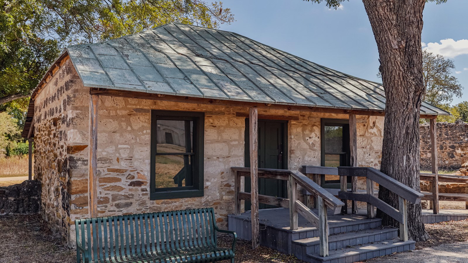 Stone house with steps and a ramp leading to the one door entrance. 