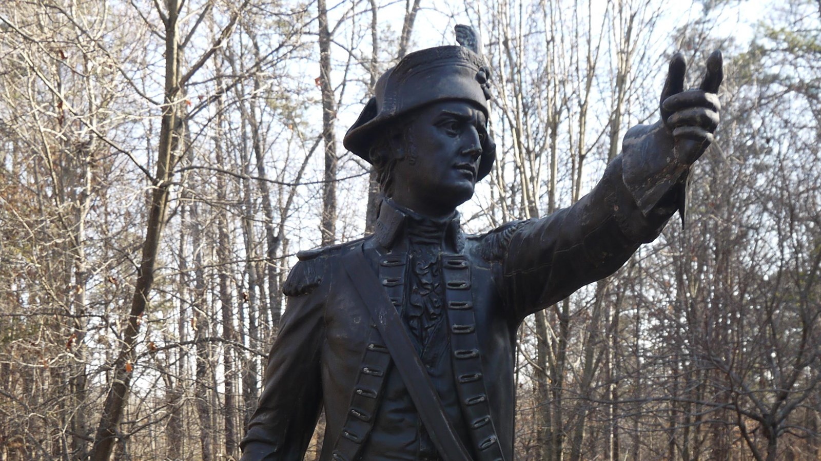 A bronze statue of Major Joseph Winston stands atop a granite pedestal and points forward.