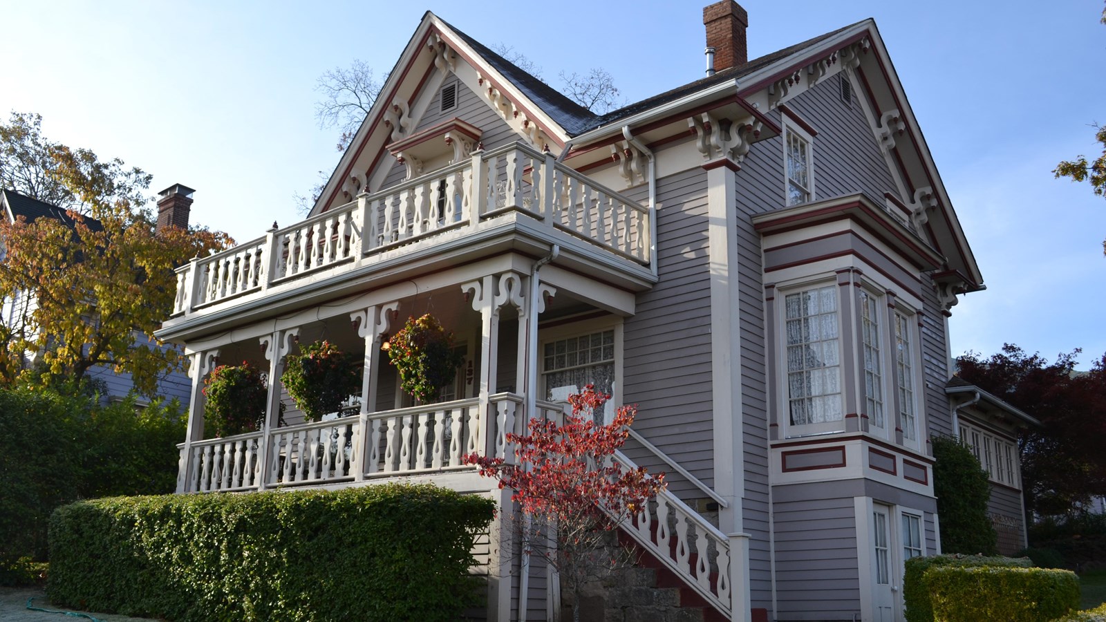 Blue two story house with ornate porch. 