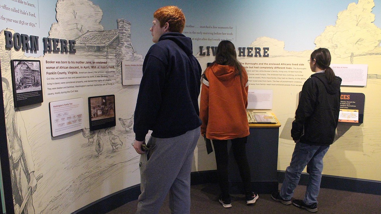 A group of visitors reading at an exhibit  