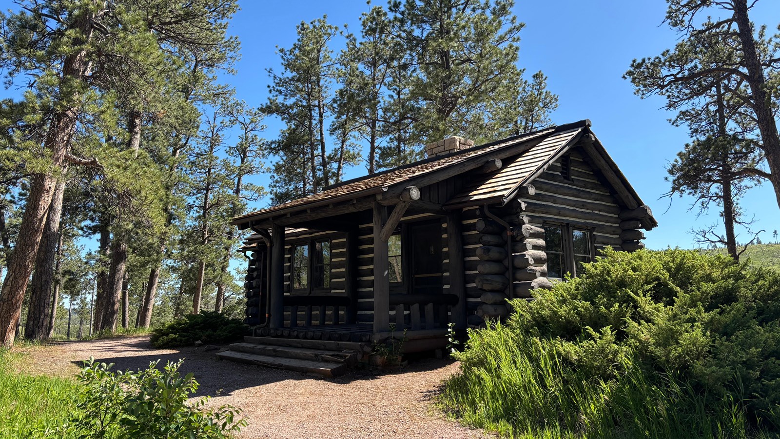 The Historic Ranger Station, a small log cabin with stairs and a covered porch.