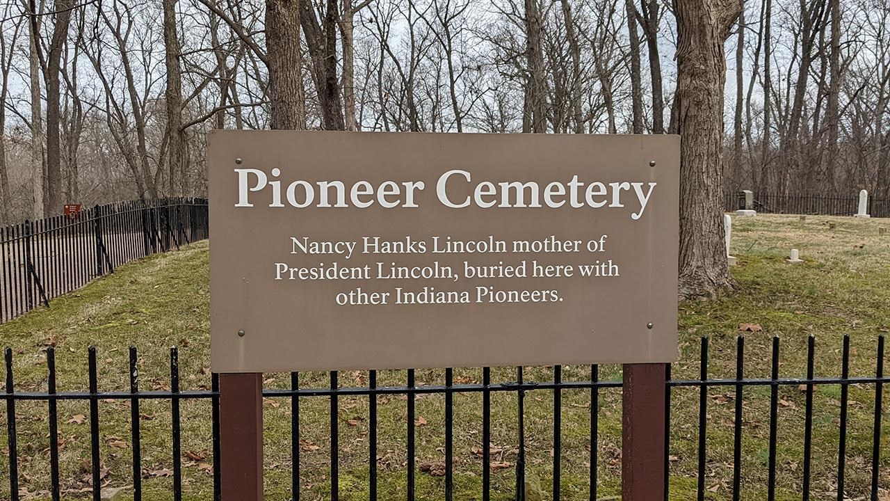 Brown sign that says Pioneer Cemetery Nancy Hanks Lincoln mother of Abraham Lincoln, buried here.
