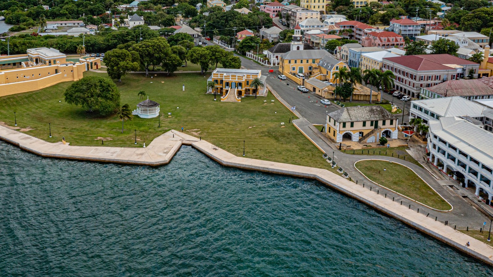 Photo of the wharf with colonial buildings and the sea