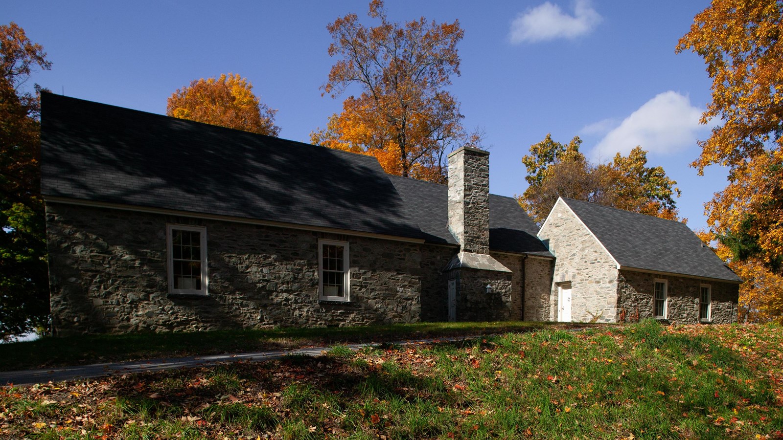 Fieldstone house on the crest of a broad hill.