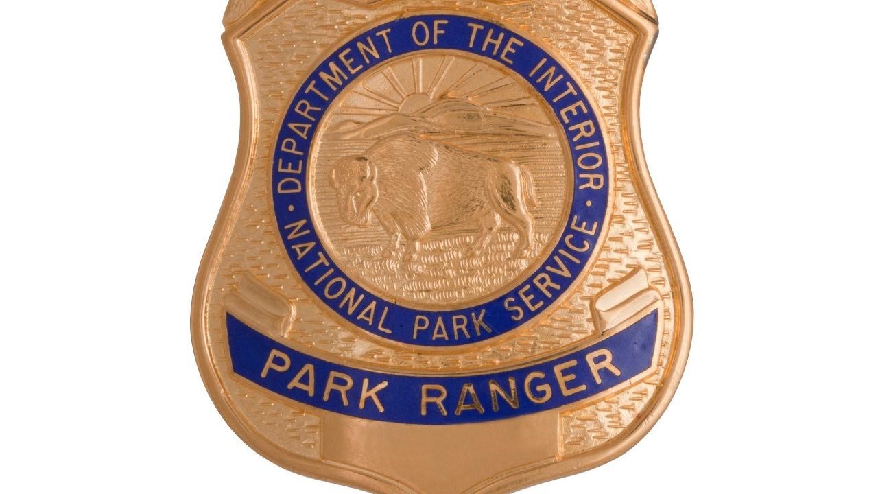 A bronze National Park Service Ranger badge with US Government and Park Ranger