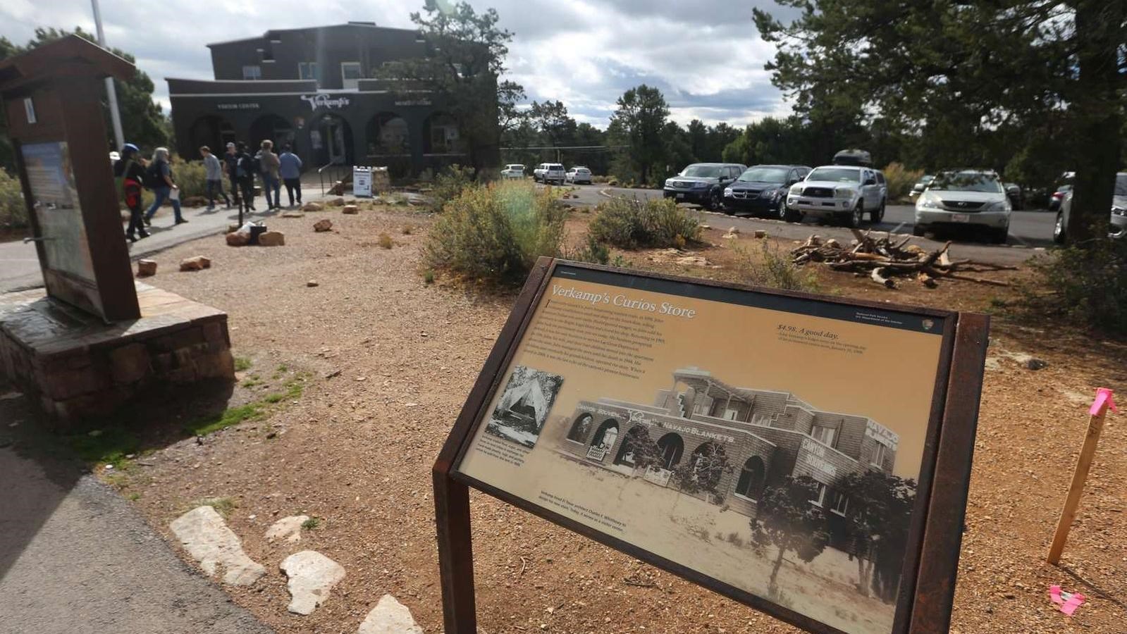 An exhibit sign explains the historical significance of the craftsman style building behind it.