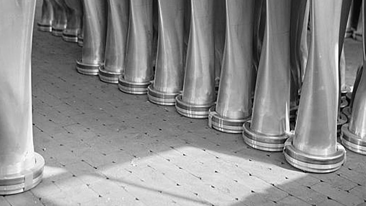 large shaped metal columns or propellers stand in a row