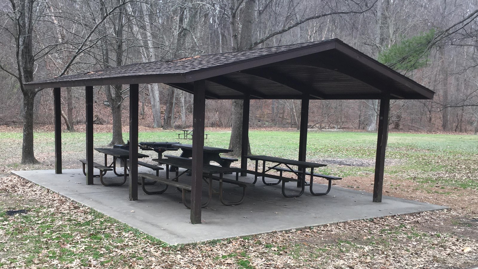 Several picnic tables under an open air pavilion