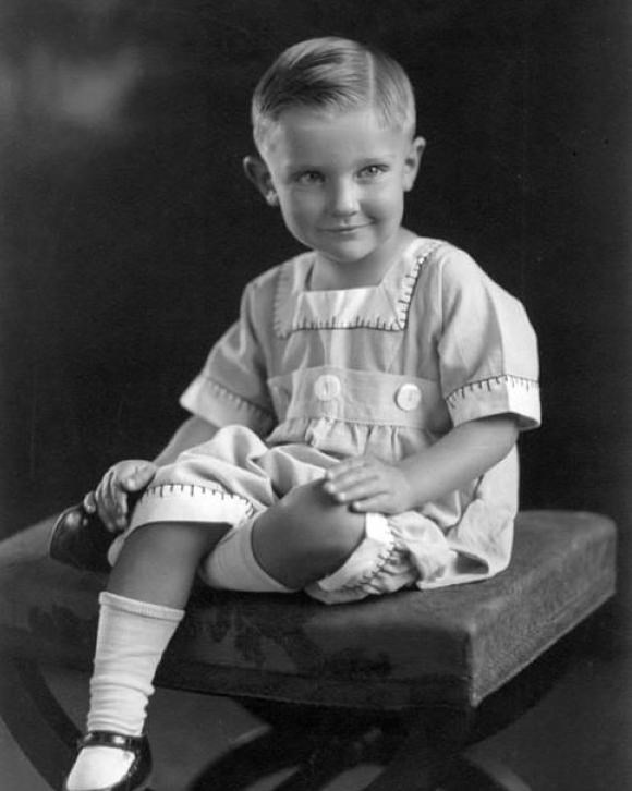 A black and white image showing a young boy wearing dress clothes