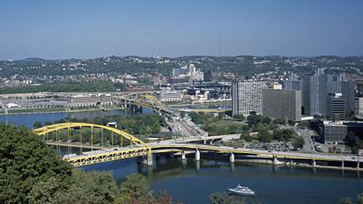 City buildings along a river with a large bridge connecting the city across the river