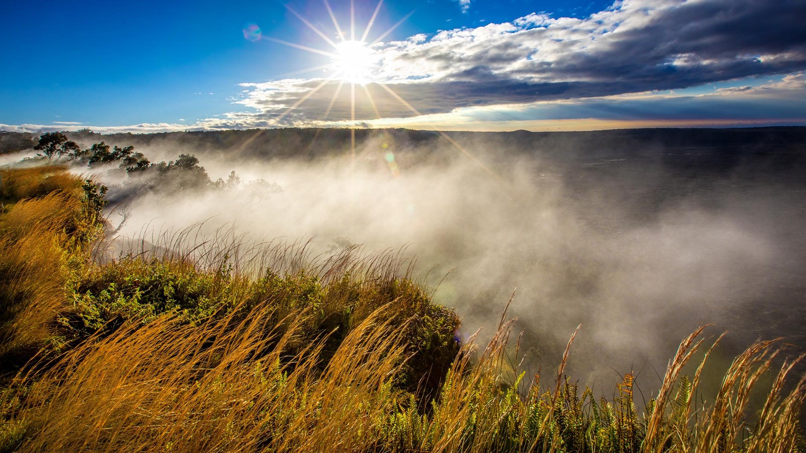 Steam rising from a cliff edge at sunrise