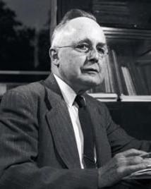 Man in suit with glasses poses for picture.