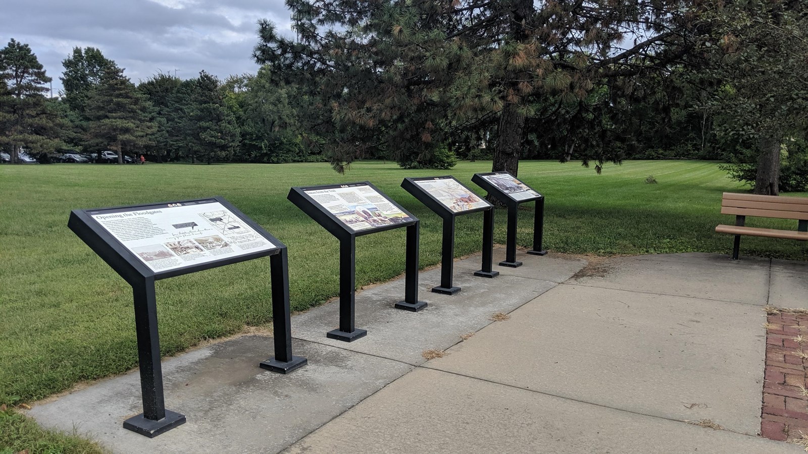 Wayside exhibits in front of a grassy field.