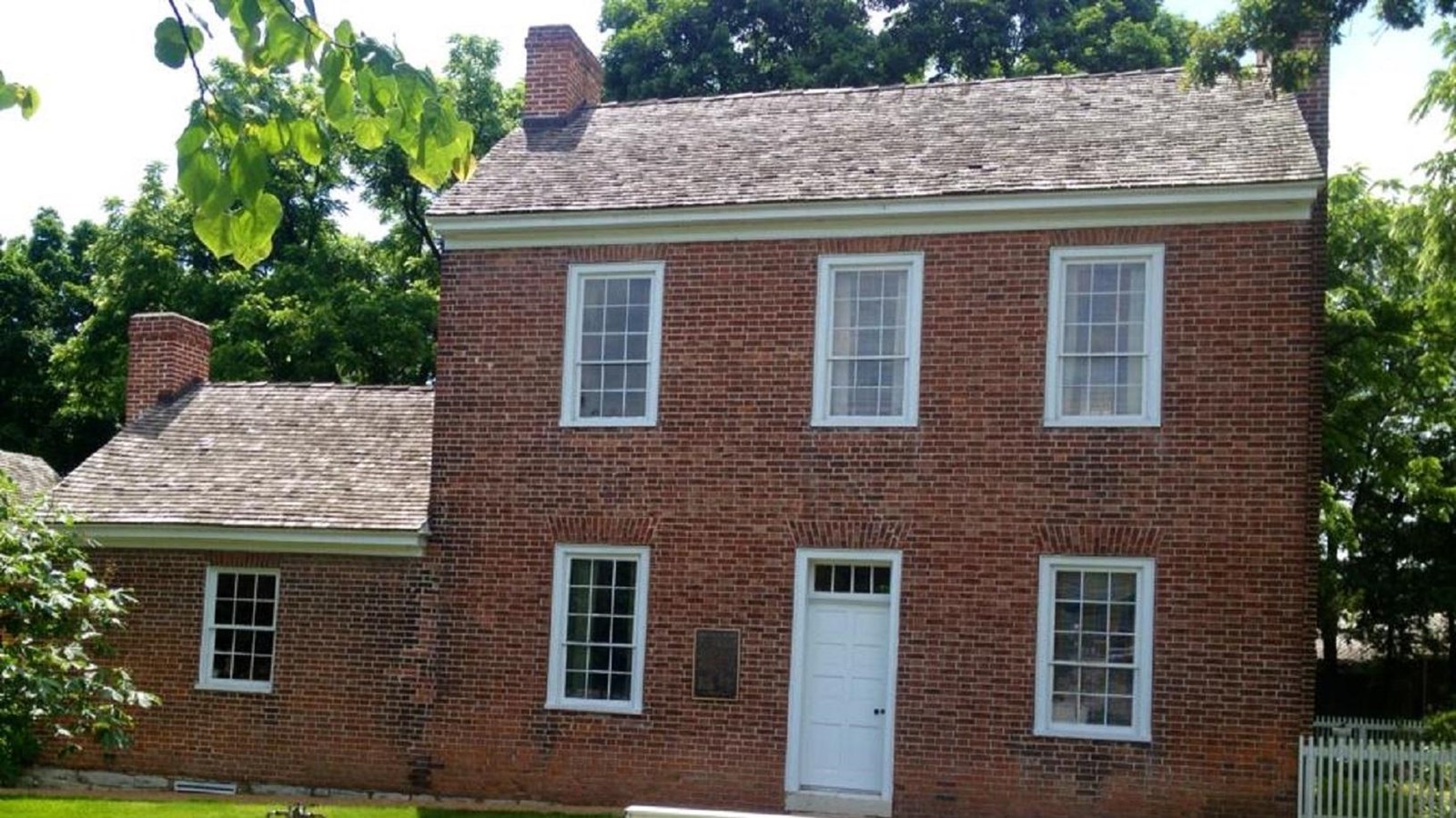 two-story brick home in background with foreground sign, 