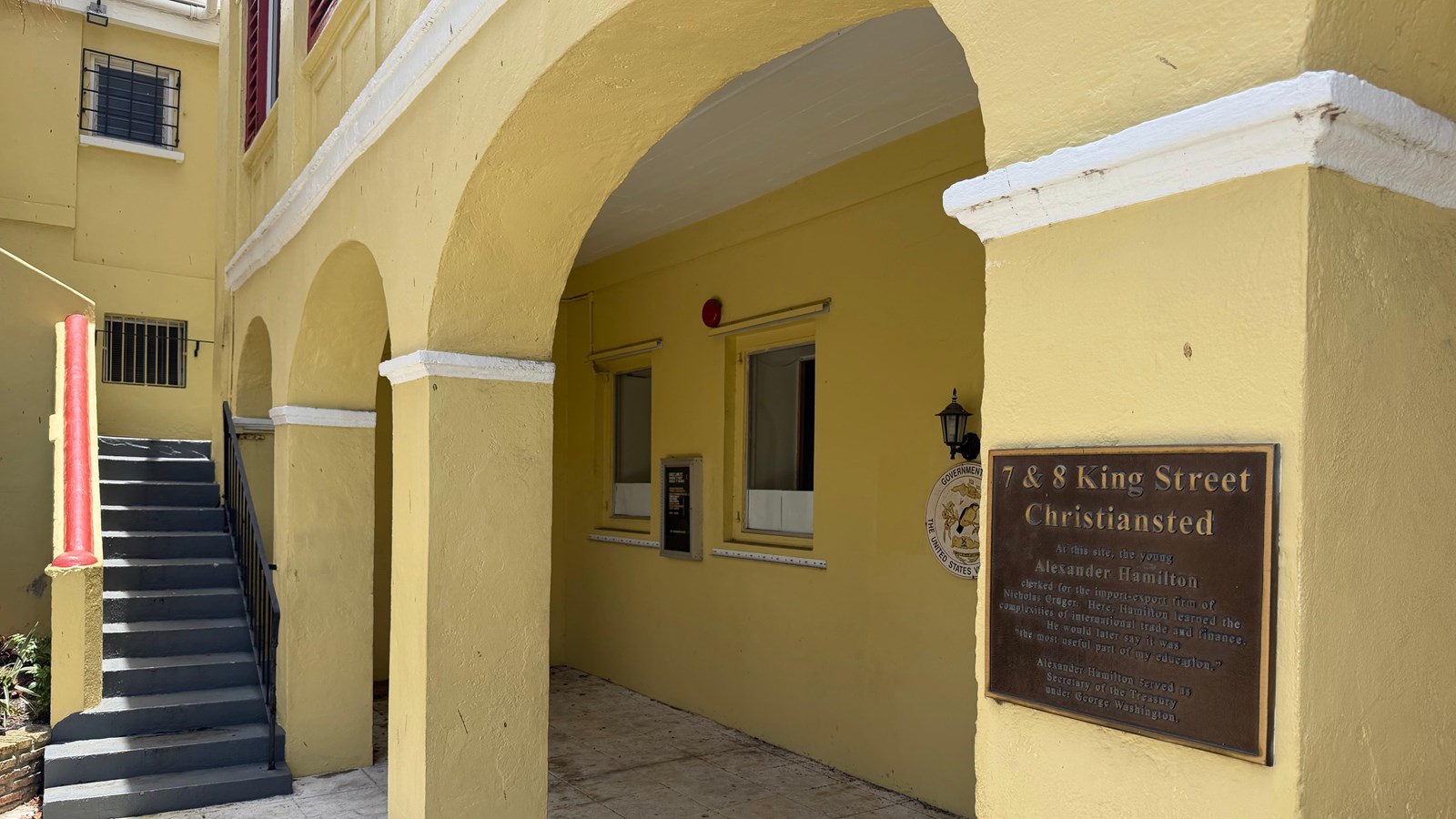 A yellow building with a plaque about its historical signifigance