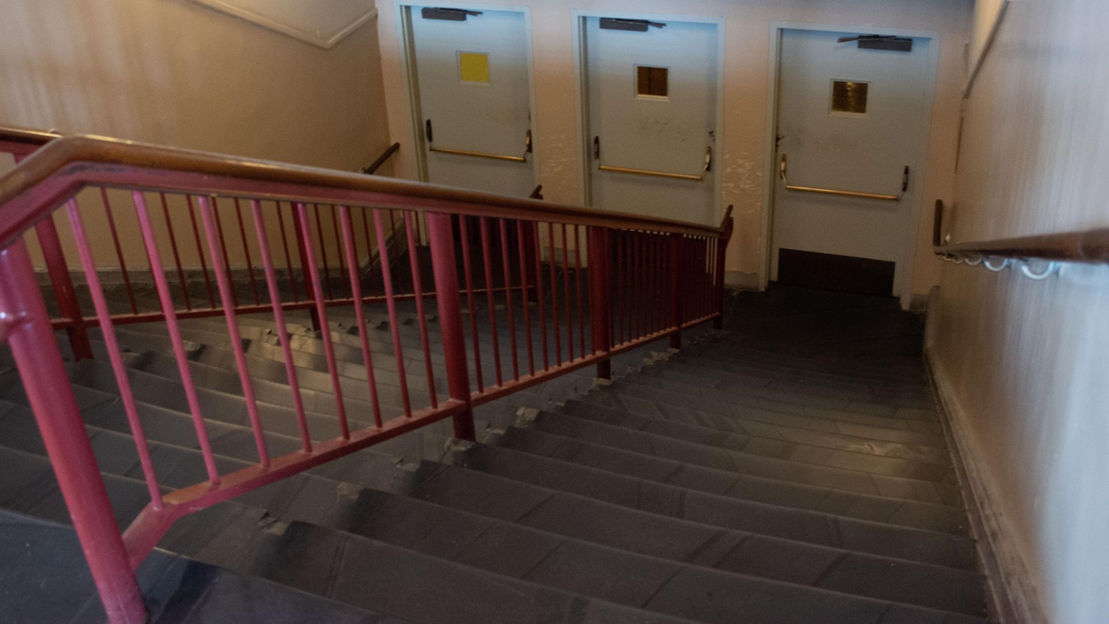 Looking down a flight of stairs with three doors at the bottom