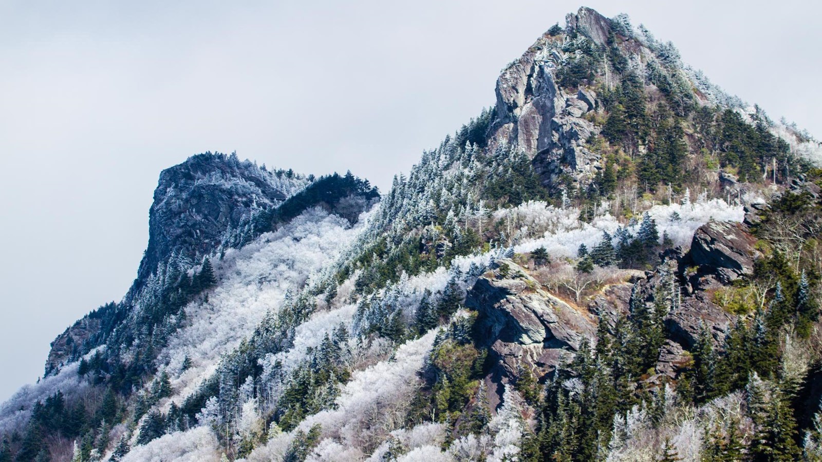 Two rugged and rocky mountain peaks covered with snow and frost