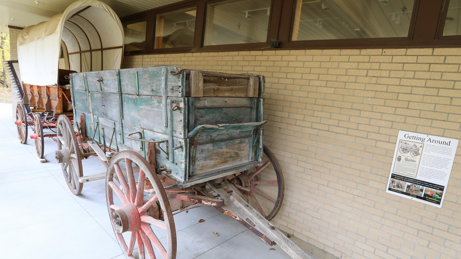 A covered wagon lined up behind a supplies wagon.