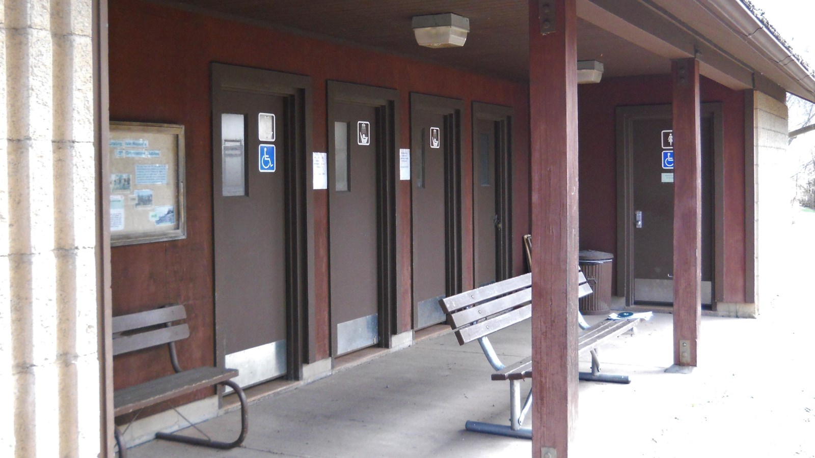 A building with four doors, two benches, and two pillars. 