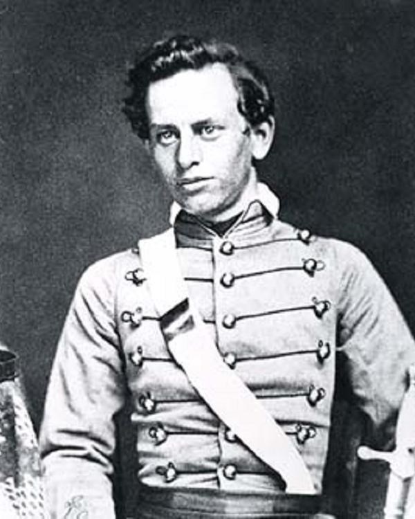 Black and white photograph of a man win a military dress uniform with a strap across his chest 
