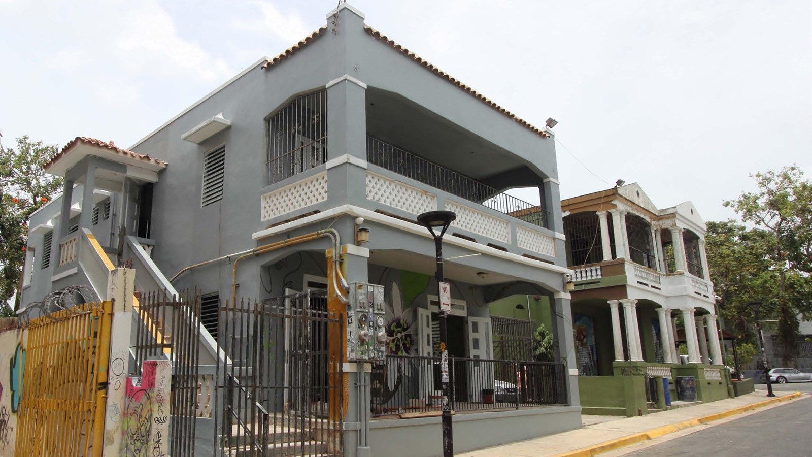 Image of a gray-blue two-story Spanish Revival style building.