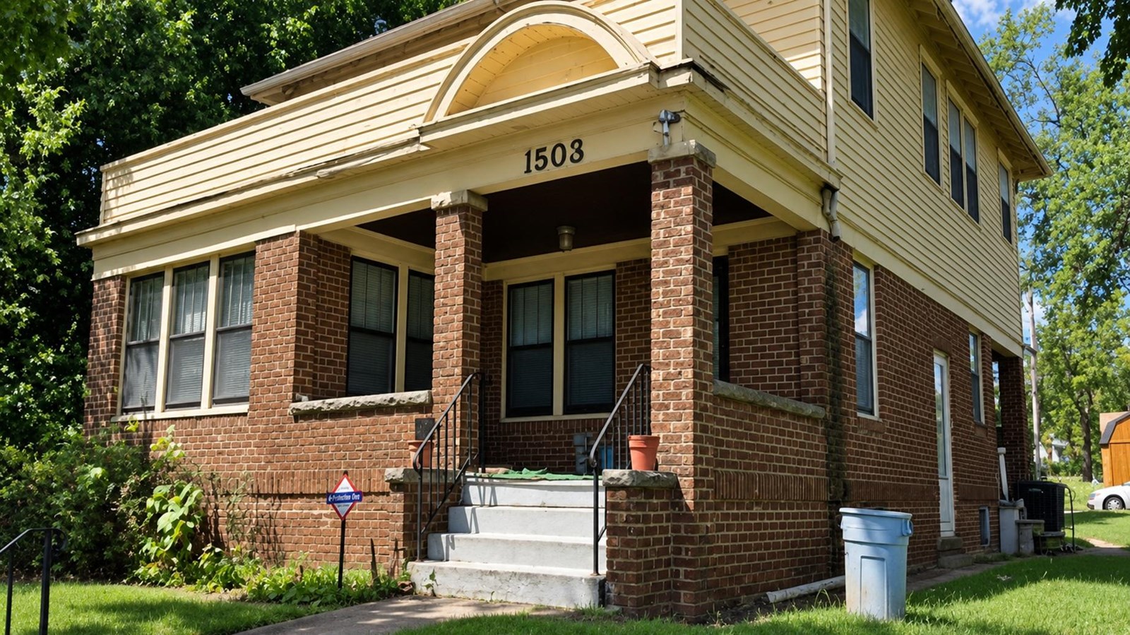 A brick and yellow sided two-story home.