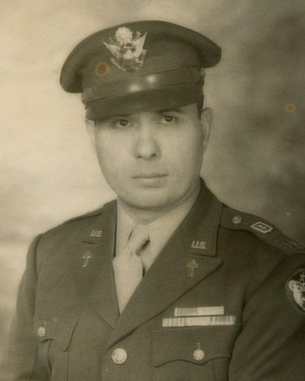 Portrait of a man in uniform with isgnia on jacket and a hat. 