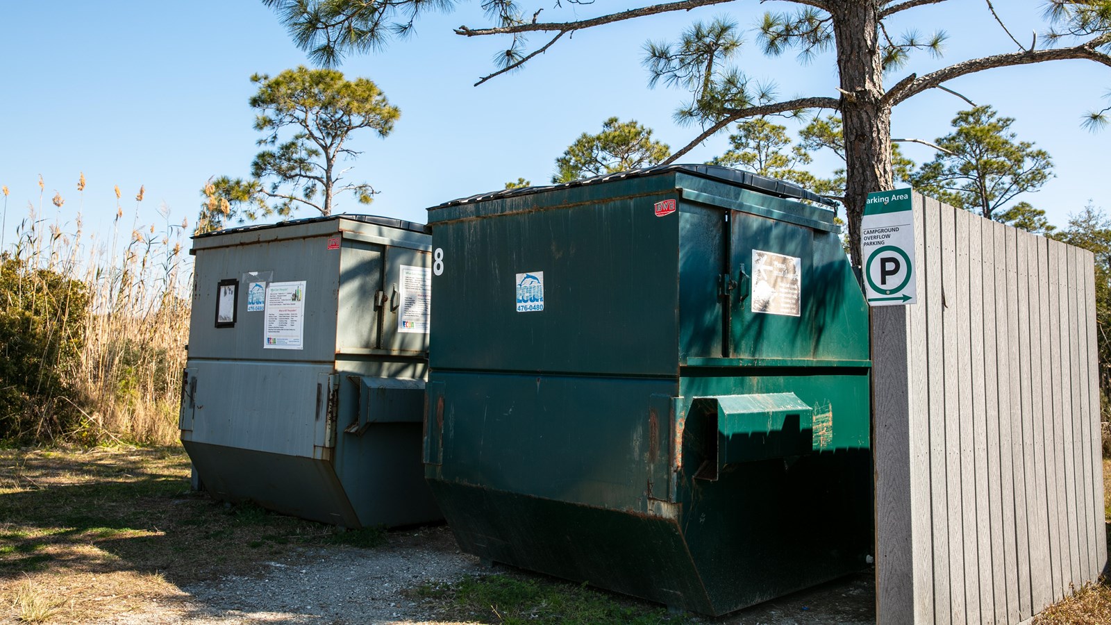 A trash and recycling bin stand in the Fort Pickens campground.