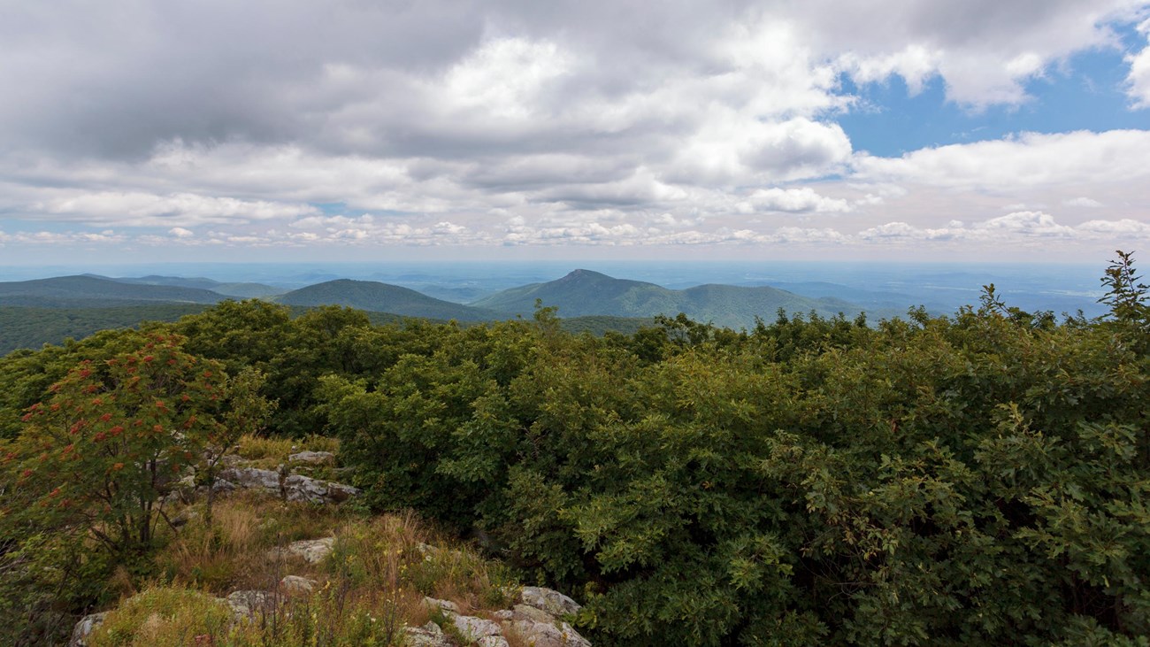 A view from on top of the summit of a mountain.