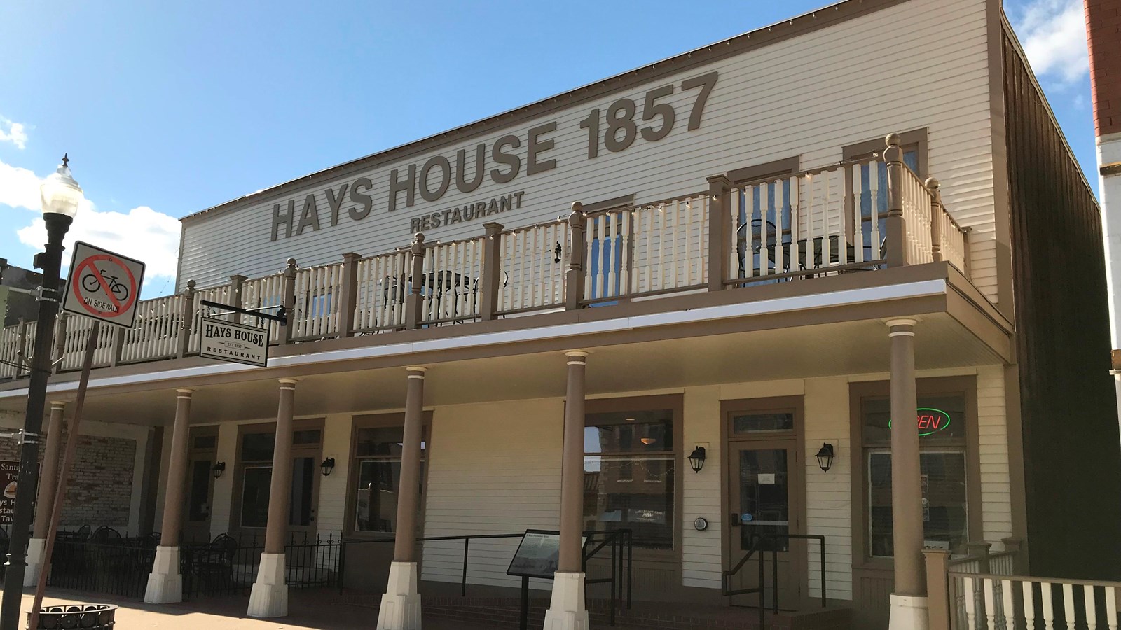 A large two-story historic building with an upstairs veranda and 