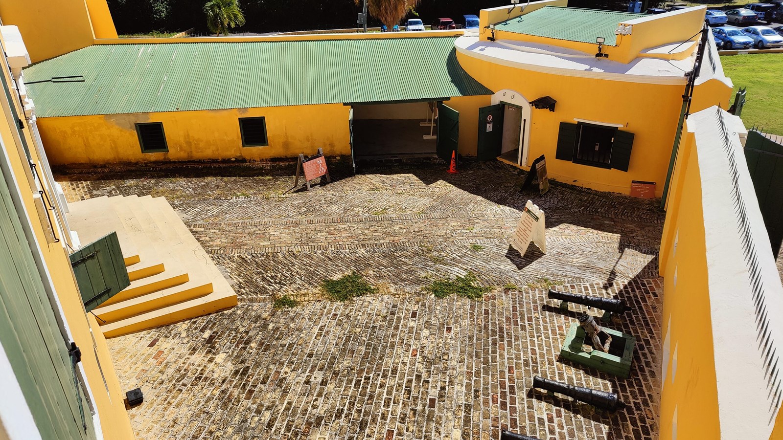 Photo of walled triangular courtyard housing cannon an brick floor