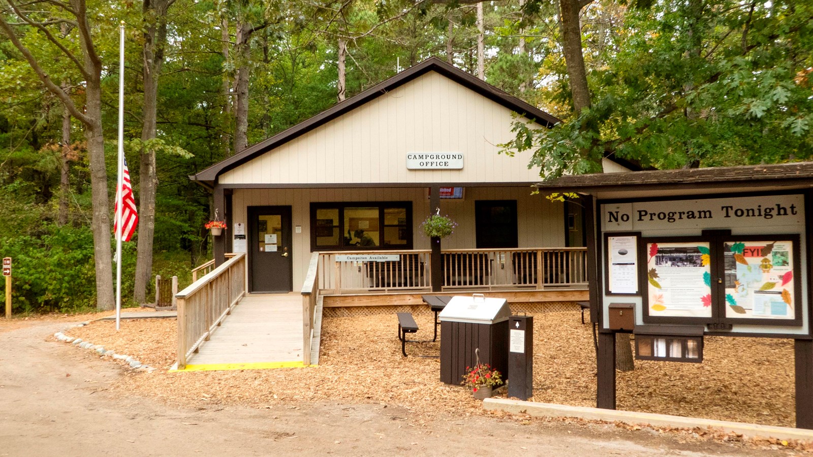 Cream-colored, peaked-roof building with ramp to covered front porch
