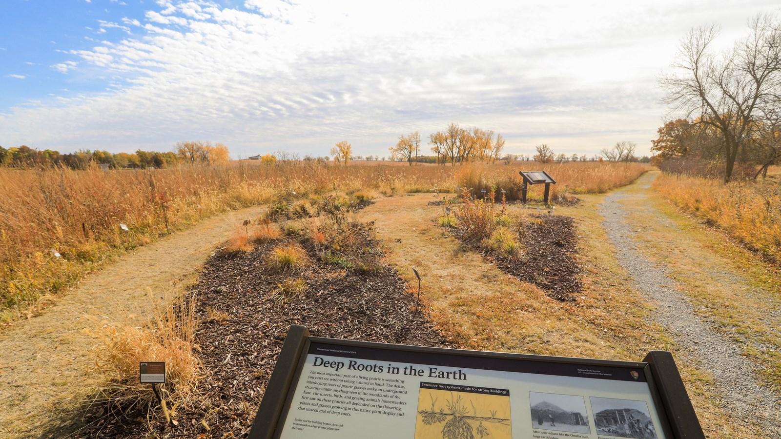 Wayside visible in front of a native plant display garden and restored tallgrass prairie.