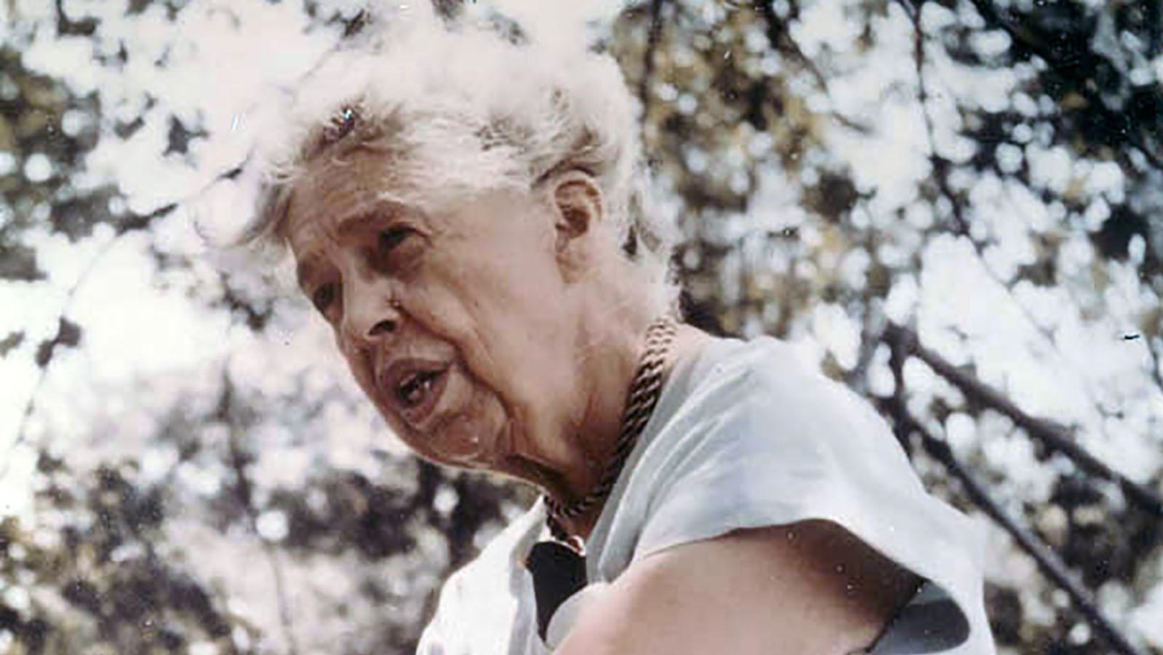 A head and shoulder portrait of a woman (Eleanor Roosevelt) wearing a light blue dress outdoors.