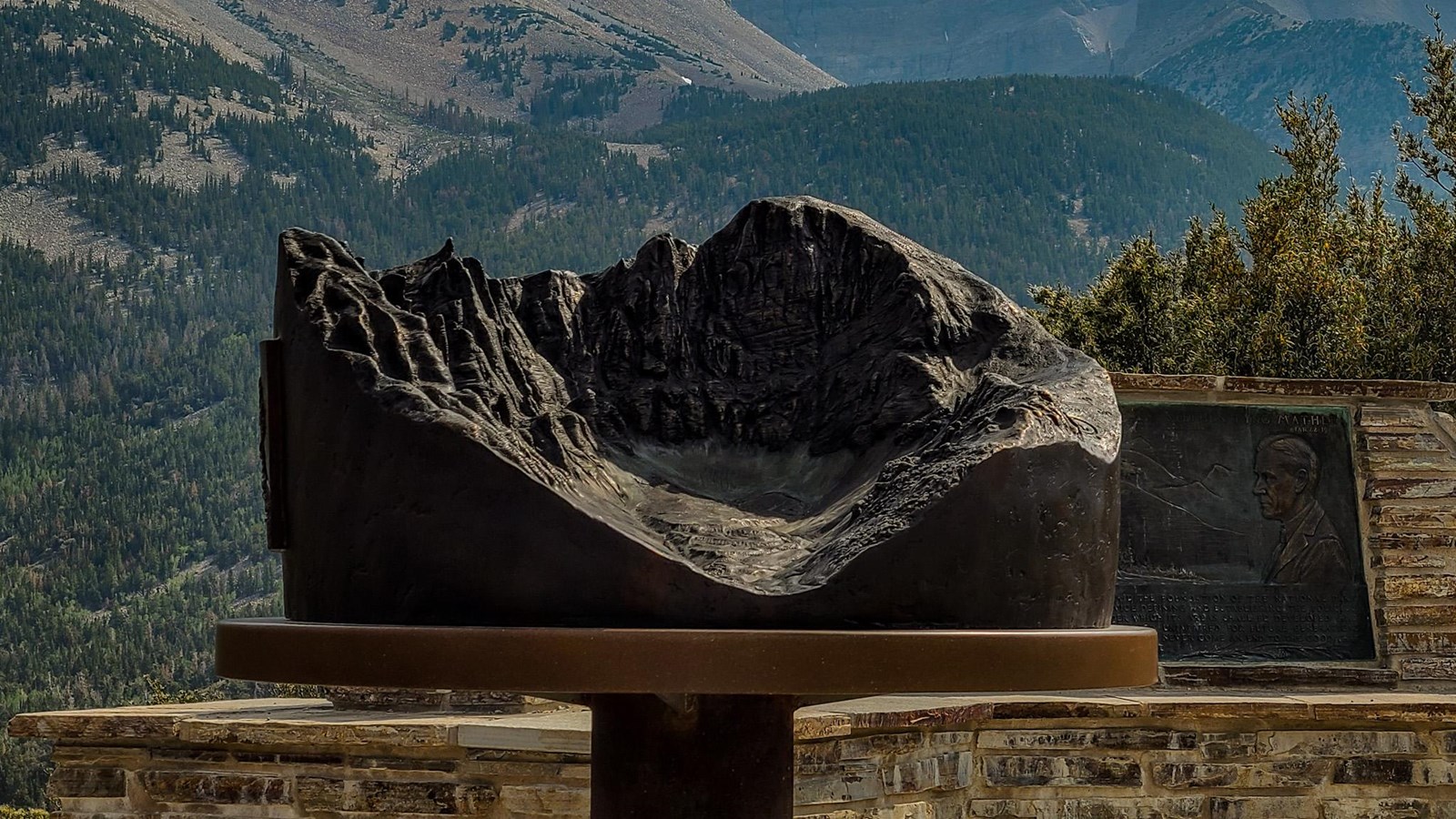 A bronze relief map stands in front of views of a bare wheeler peak and the Mather plaque.