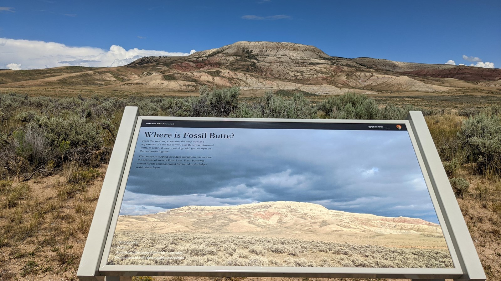 An angled sign with a picture of the butte facing the butte.