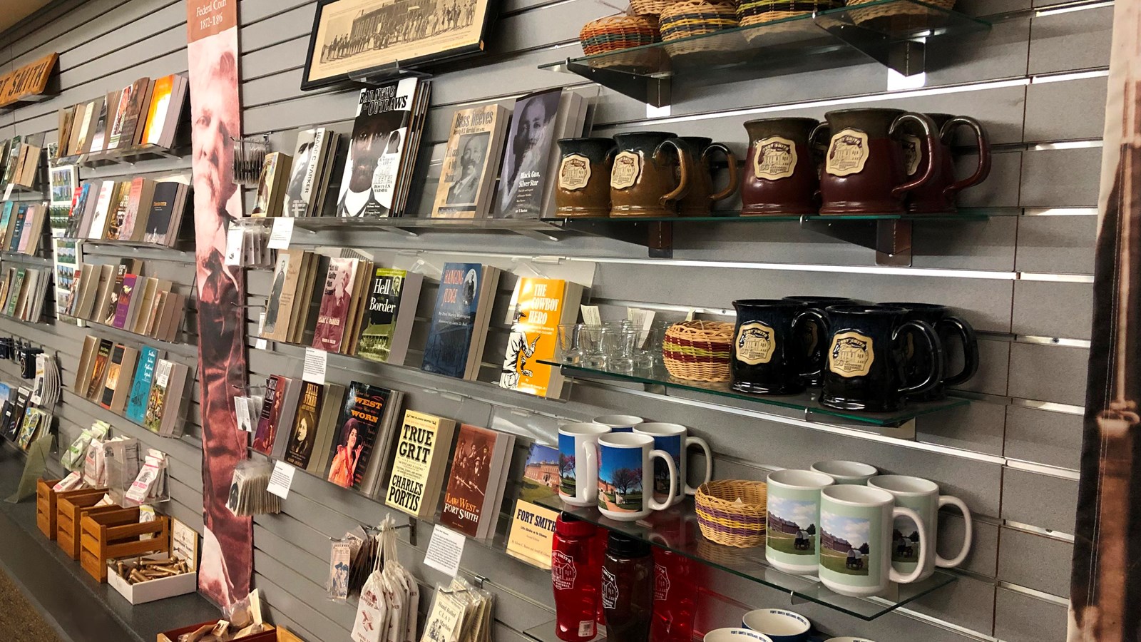 Mugs, baskets, books, and toys, stock clear shelves on a gray wall. 