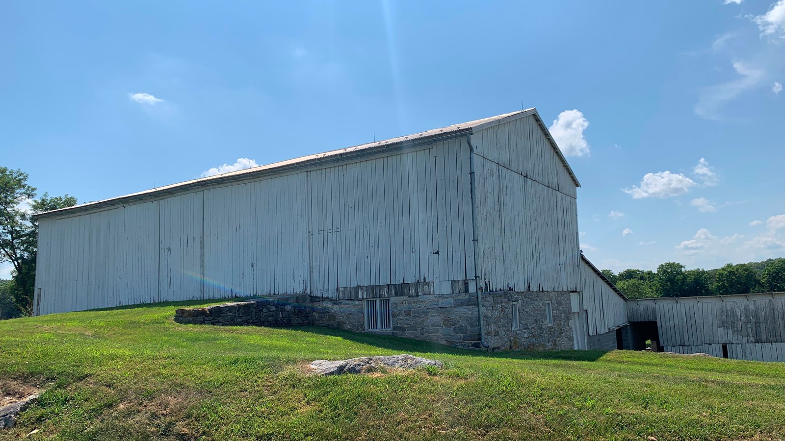 white barn with grass driveway
