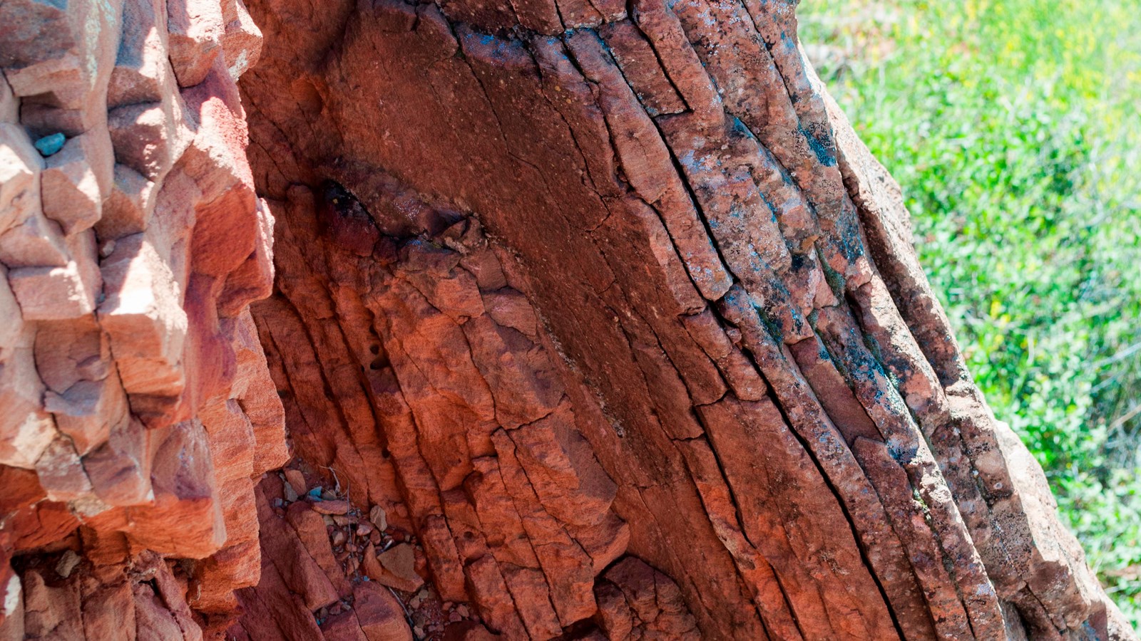 A piece of red rock with cracks angled down and to the right.