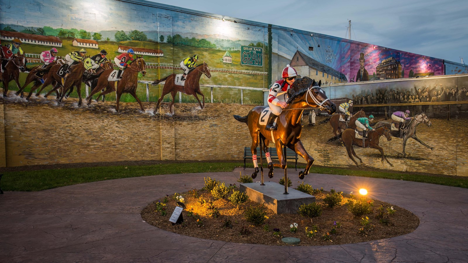 Horse racing statue and mural at an art park.