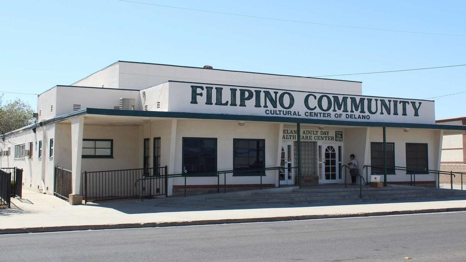 A light colored building with 4 windows. Large lettering says 