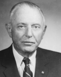 Man in suit poses for picture.