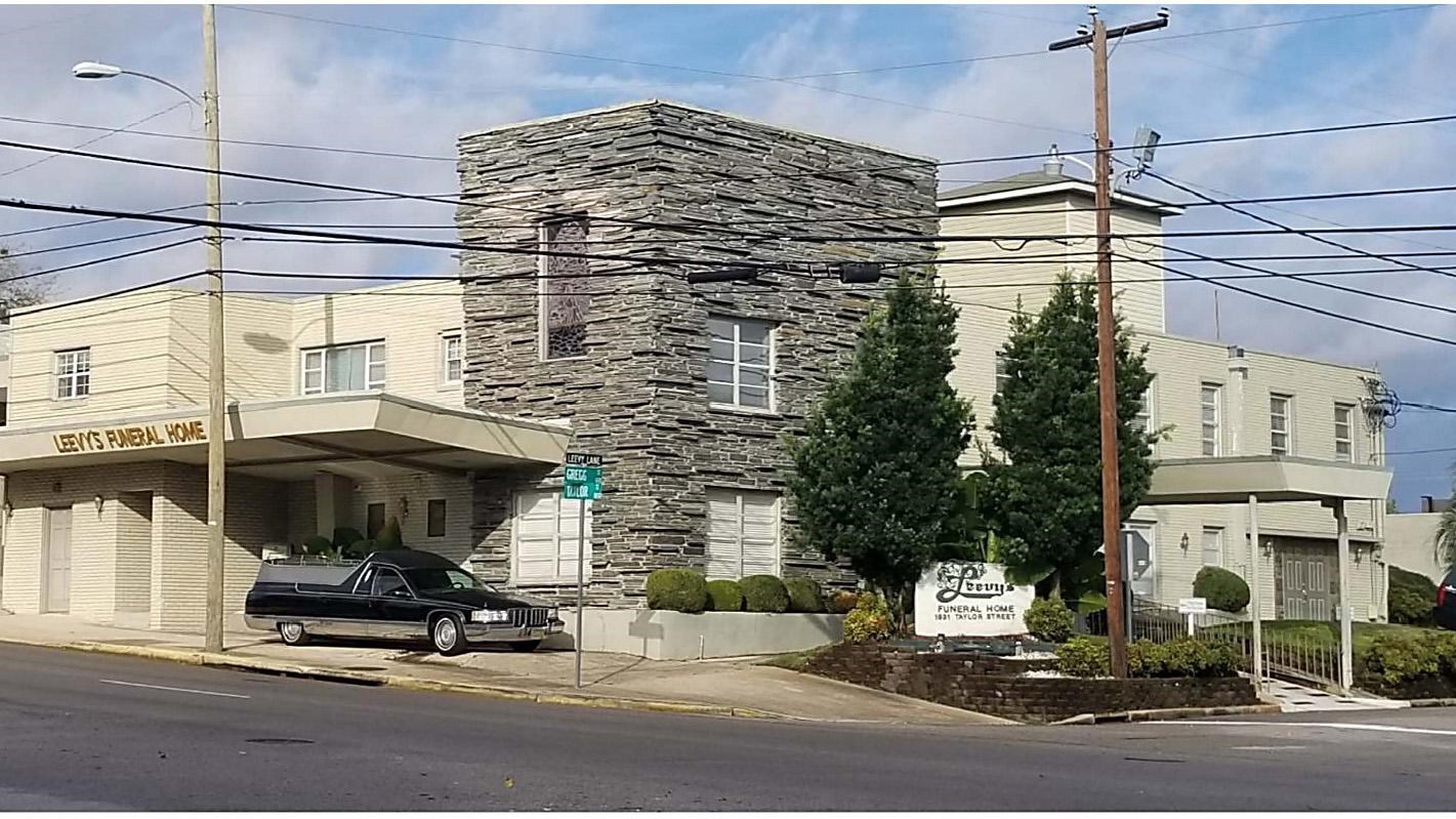 a two-story building with covered entranceways and a prominent slate-stone facade