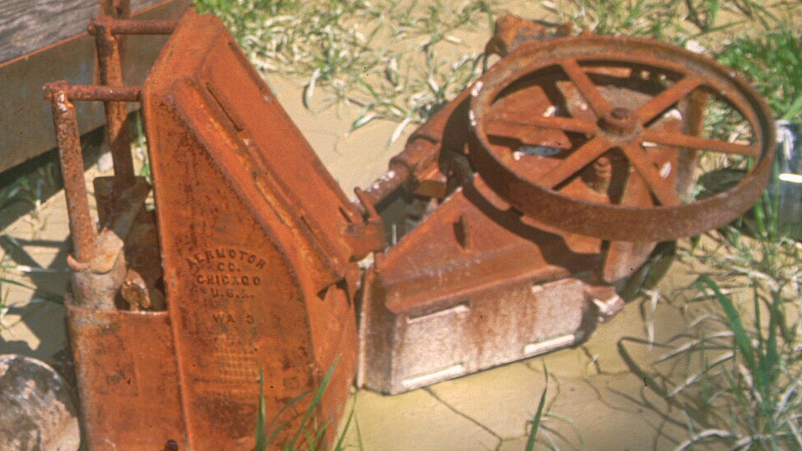 rusted water pump with wheel. 