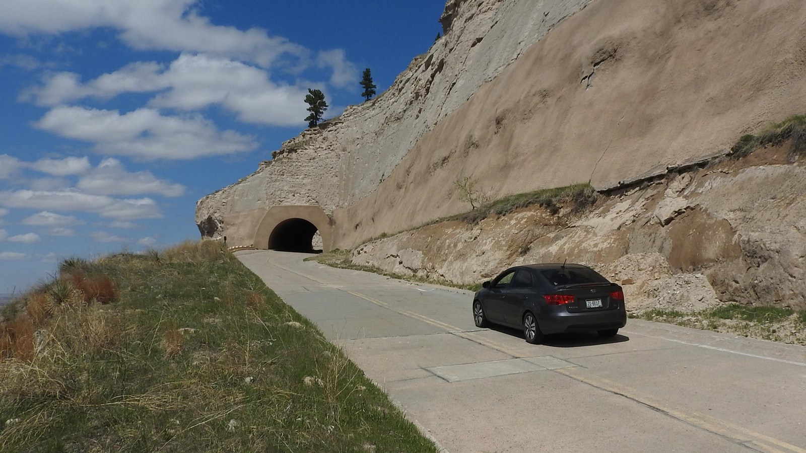 A car approaches one of the tunnels on the Summit Road. 