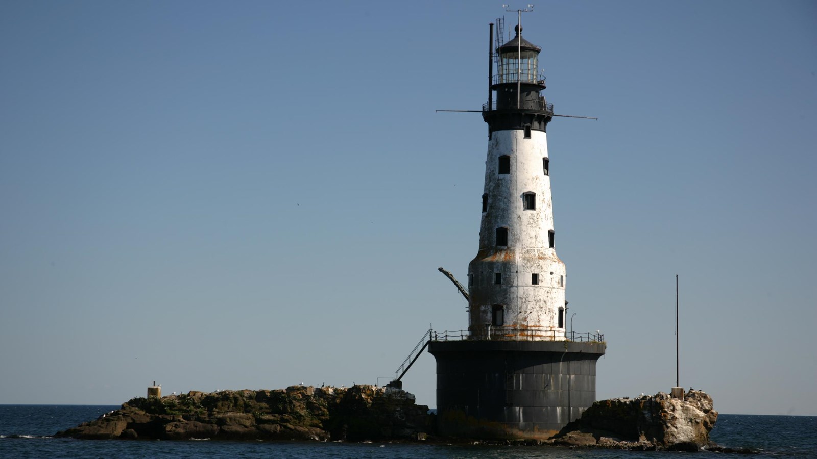 image of a lighthouse jutting up from a desolate, tiny rocky reef