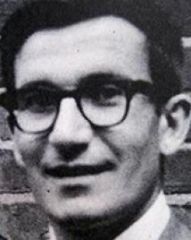 Man in suit and glasses poses for picture