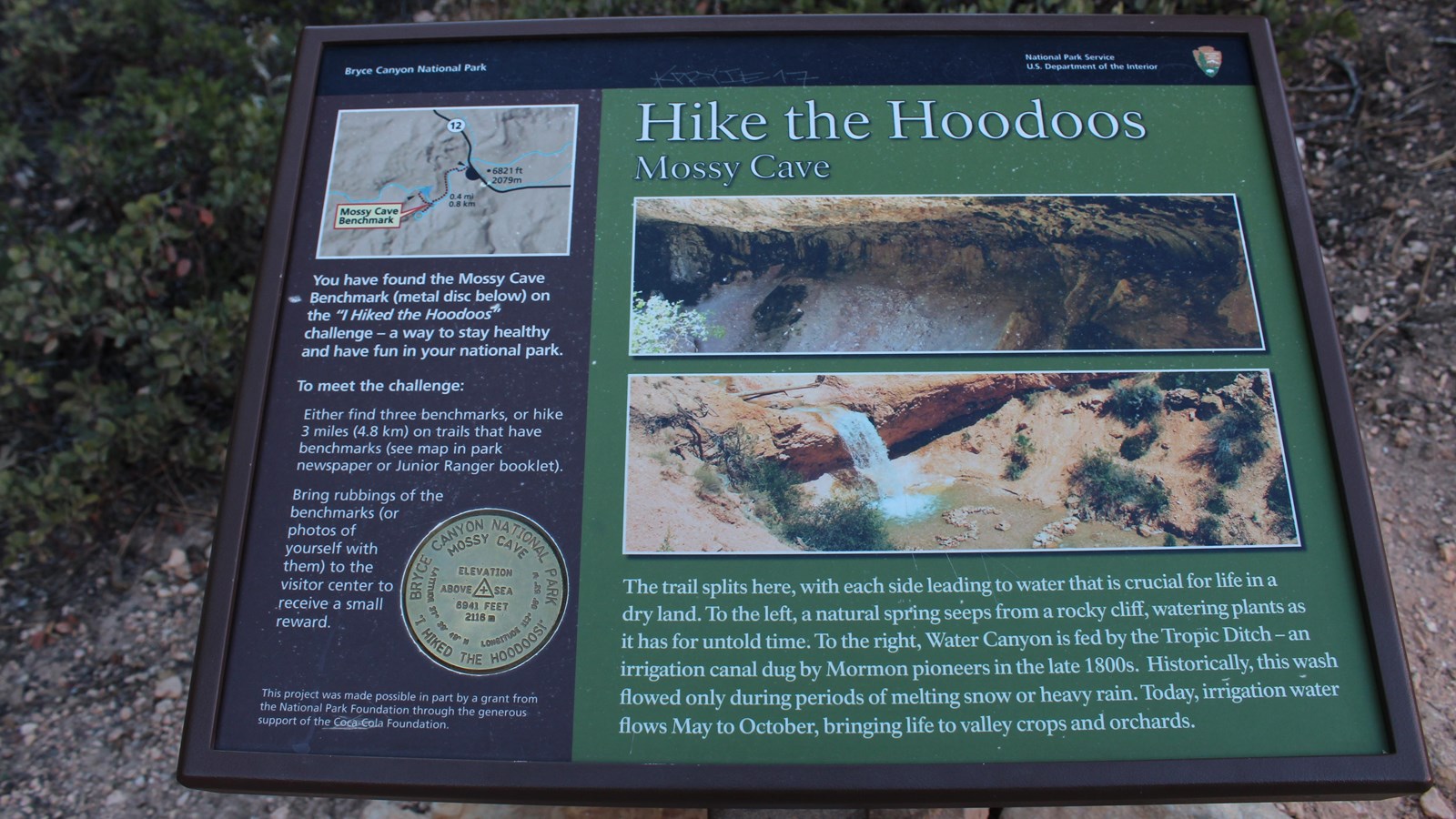 A wayside panel with a waterfall describes the hike the hoodoos program and how to obtain a reward