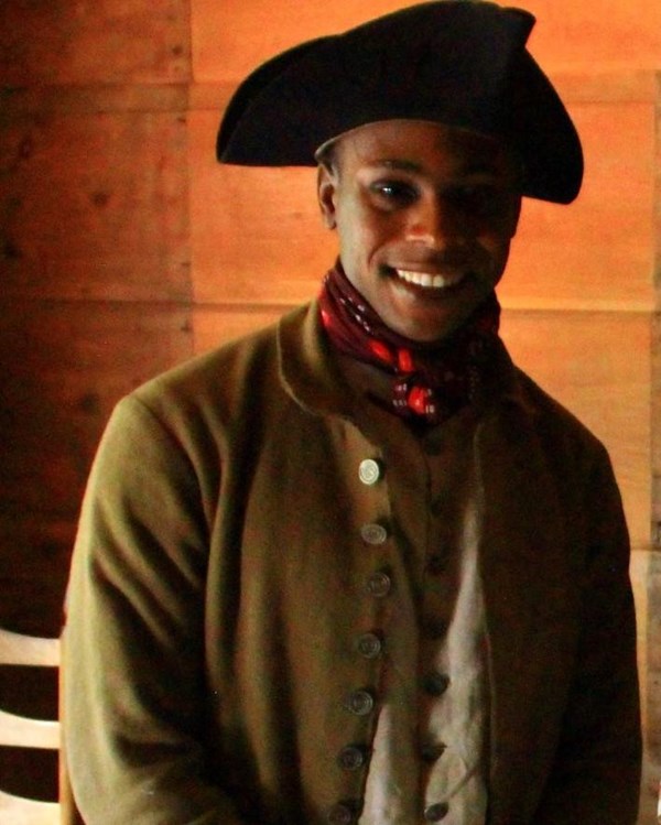 Revolutionary War militia soldier in green coat, black hat and dark red neck cloth